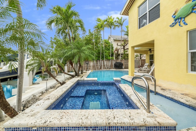 view of swimming pool featuring an in ground hot tub and ceiling fan