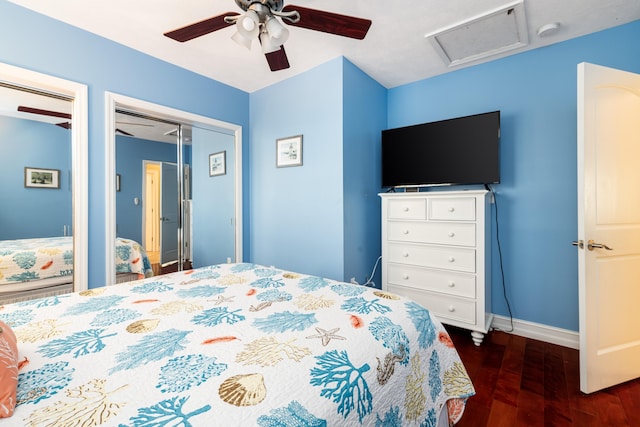 bedroom featuring multiple closets, ceiling fan, and dark hardwood / wood-style flooring