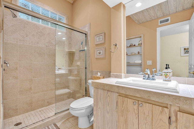 bathroom featuring tile patterned flooring, vanity, a shower with shower door, and toilet