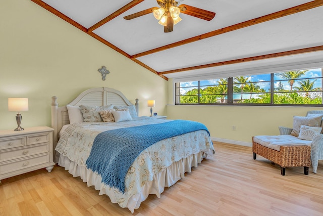 bedroom featuring ceiling fan, light hardwood / wood-style floors, and vaulted ceiling with beams