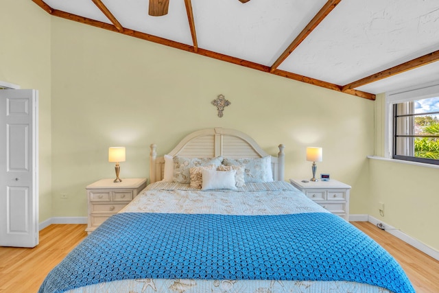 bedroom with beam ceiling, ceiling fan, and light wood-type flooring