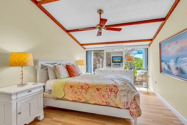 bedroom featuring ceiling fan, lofted ceiling with beams, and light wood-type flooring