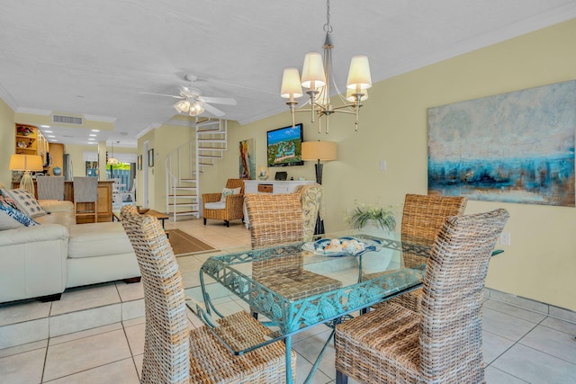 tiled dining room featuring ornamental molding and ceiling fan with notable chandelier