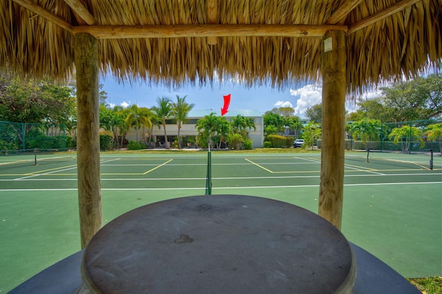 view of sport court featuring tennis court and a wealth of natural light