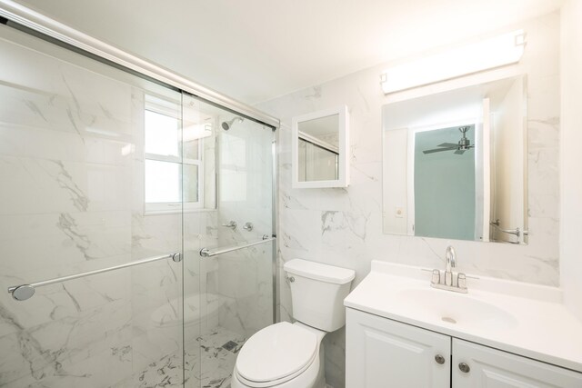 bathroom featuring vanity, a shower with shower door, tile walls, and toilet