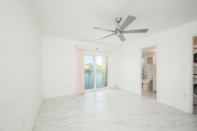 spare room with ceiling fan and stacked washer / dryer