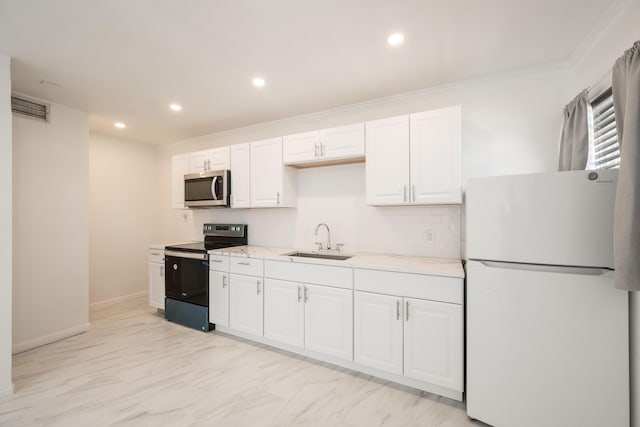 kitchen with sink, white cabinets, decorative backsplash, white fridge, and black range with electric cooktop