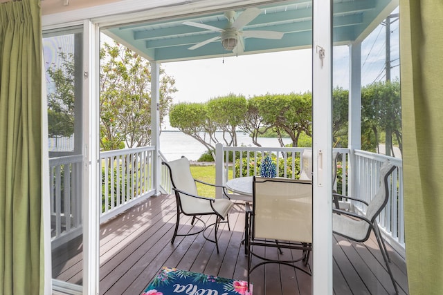 wooden deck featuring outdoor dining area and a ceiling fan