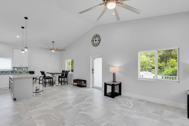 811 La Paloma Rd, Key Largo, FL 33037 - living room featuring a ceiling fan, high vaulted ceiling, baseboards, and light marble finish floors