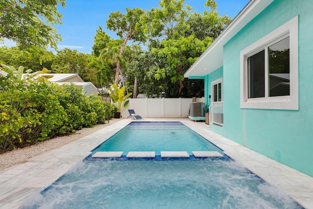 811 La Paloma Rd, Key Largo, FL 33037 - view of pool featuring a pool with connected hot tub, a fenced backyard, and central air condition unit