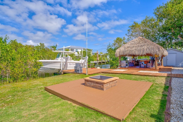 exterior space featuring a gazebo, a water view, a storage unit, and an outdoor fire pit