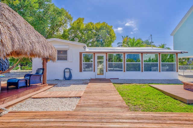 rear view of property with a sunroom and a deck