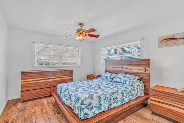 bedroom featuring multiple windows, ceiling fan, and light wood-type flooring