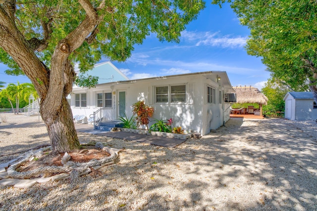 ranch-style home with a storage shed