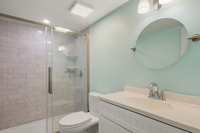 bathroom with vanity, a shower with shower door, and toilet