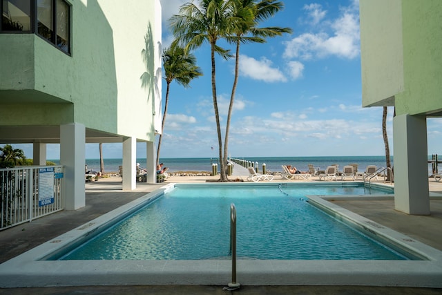 view of swimming pool with a patio and a water view