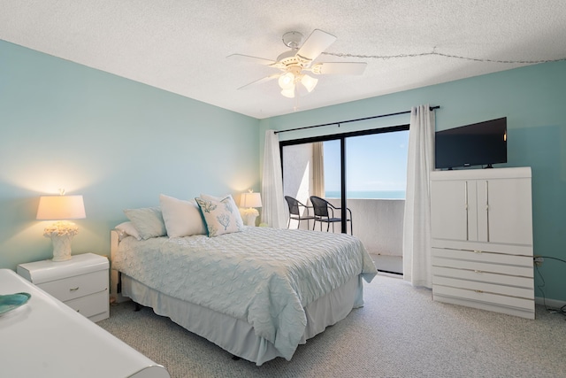 carpeted bedroom with ceiling fan, access to outside, and a textured ceiling