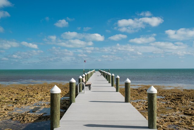 dock area with a water view and a beach view