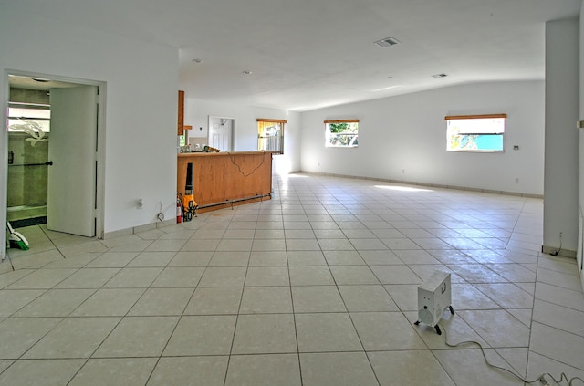 tiled spare room featuring lofted ceiling and a healthy amount of sunlight