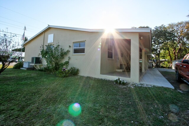 rear view of house with a storage shed, a lawn, and a patio