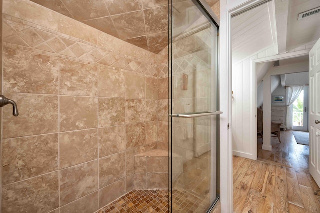 bathroom with an enclosed shower and hardwood / wood-style floors