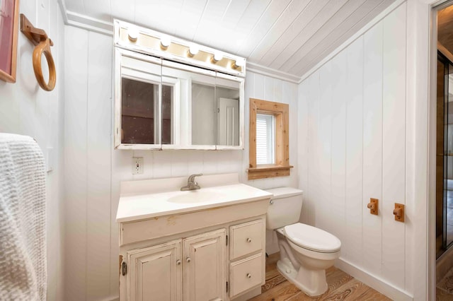 bathroom with vanity, wood-type flooring, wooden walls, and toilet