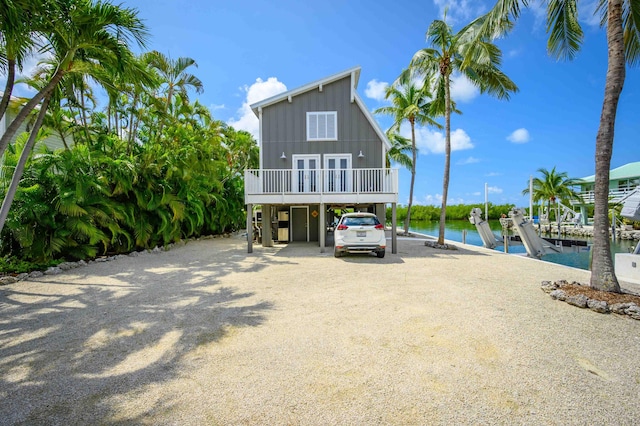 coastal home featuring a carport, a boat dock, and a water view