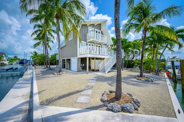 view of front of property featuring a balcony and a water view