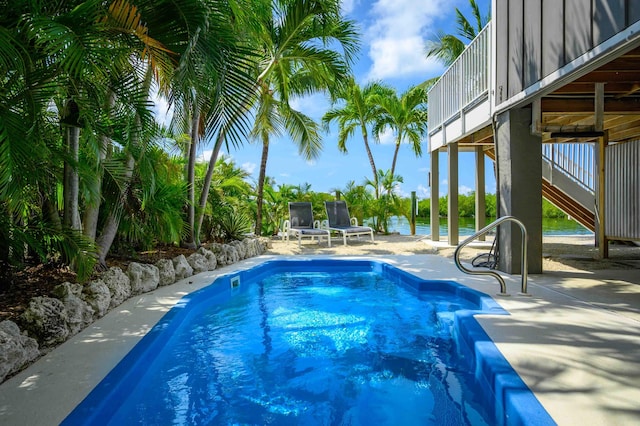 view of swimming pool with a patio and a water view