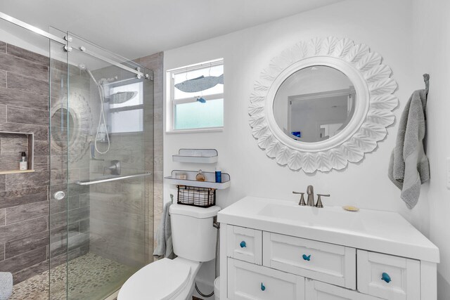 bathroom with walk in shower, vanity, and toilet