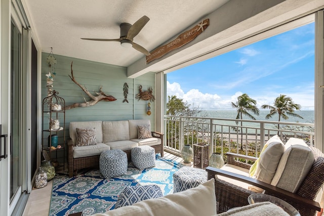 balcony with a water view, ceiling fan, and outdoor lounge area