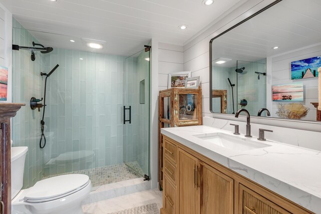 bathroom featuring vanity, a shower with shower door, and toilet