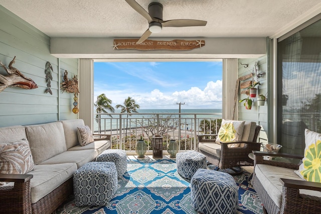 sunroom / solarium featuring a water view and ceiling fan