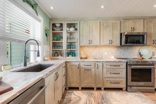 kitchen with sink, wood ceiling, stainless steel appliances, tasteful backsplash, and light stone countertops