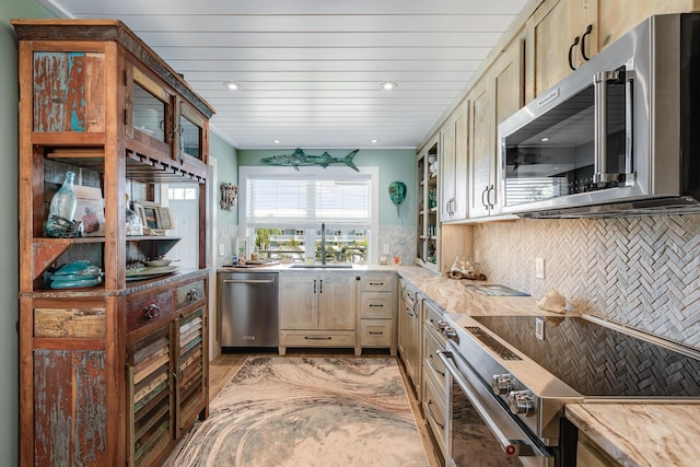 kitchen with tasteful backsplash, sink, light brown cabinetry, and appliances with stainless steel finishes