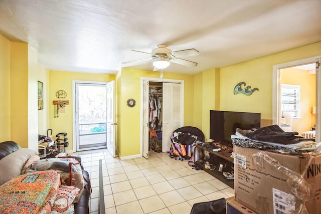 living room with light tile patterned floors, a ceiling fan, and baseboards