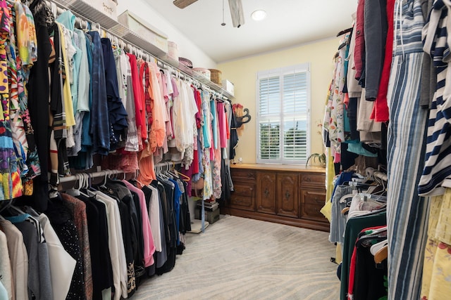 spacious closet with light carpet and ceiling fan