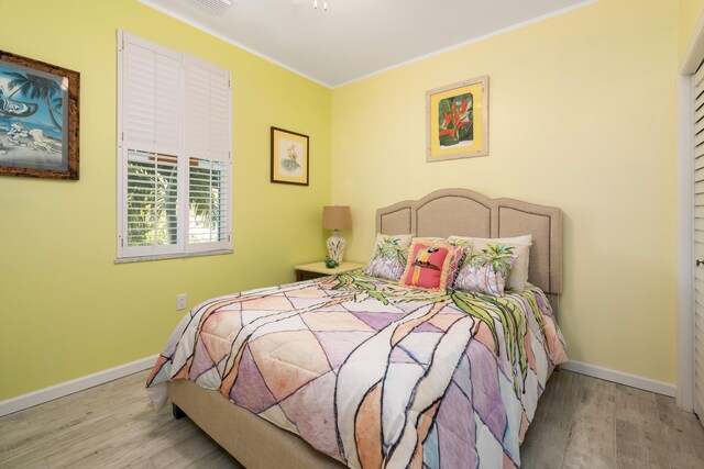 bedroom with crown molding and light hardwood / wood-style flooring