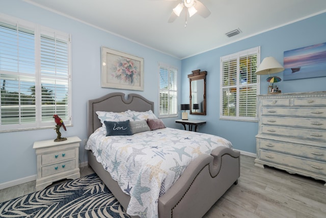 bedroom with crown molding, ceiling fan, and light wood-type flooring