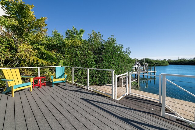 wooden terrace featuring a boat dock and a water view