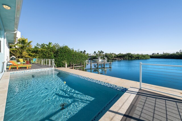 view of swimming pool featuring a deck with water view and a dock