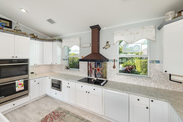 kitchen featuring white cabinetry, premium range hood, and appliances with stainless steel finishes