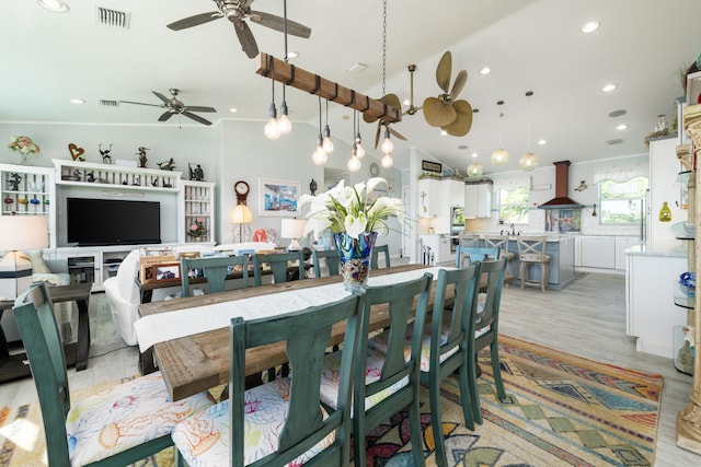 dining area featuring lofted ceiling, light hardwood / wood-style flooring, ornamental molding, and ceiling fan