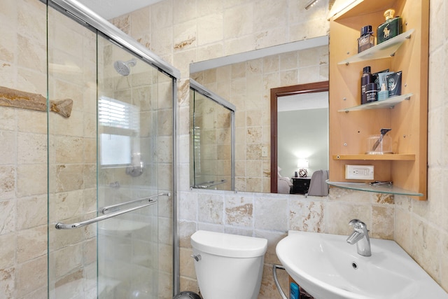 bathroom featuring sink, a shower with door, tile walls, decorative backsplash, and toilet