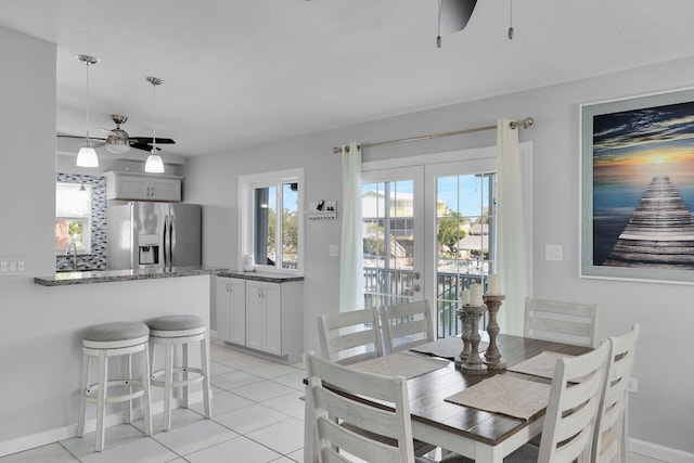 dining room with ceiling fan, light tile patterned flooring, and baseboards