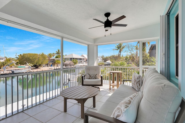 sunroom with a water view, a ceiling fan, and outdoor lounge area