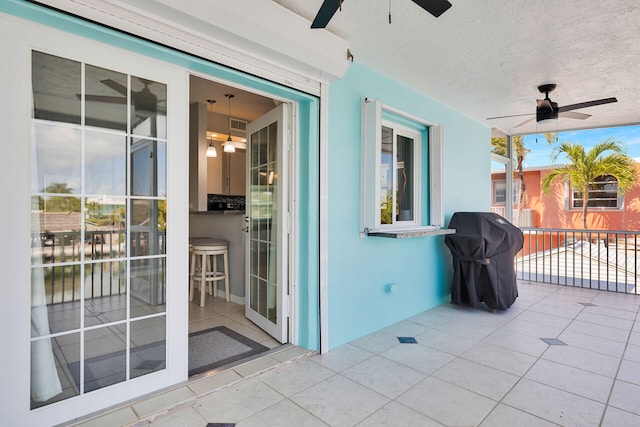 view of patio featuring ceiling fan, a grill, and a balcony