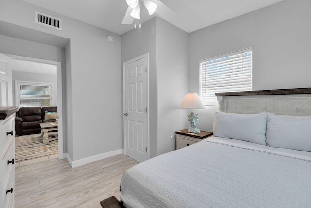 bedroom featuring light wood-type flooring, baseboards, and a ceiling fan