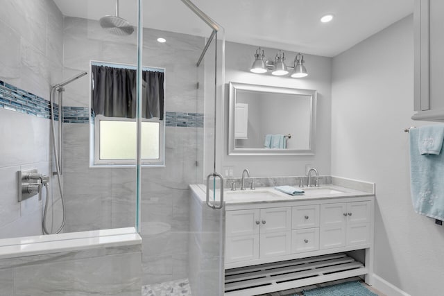 full bath with a stall shower, double vanity, baseboards, and recessed lighting
