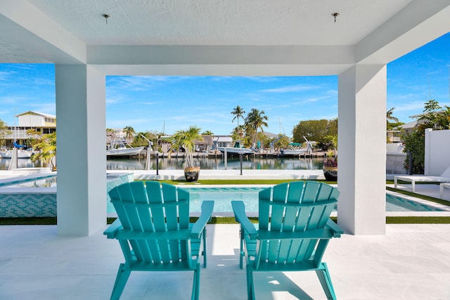 view of patio featuring an outdoor pool, a water view, a boat dock, and boat lift